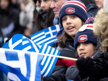 Giuliano, 9, and his brother Marco, 12, rear, support both the Canadiens and the Greek parade as they watch along the route on Jean-Talon St. during the Greek Independence Day celebrations in Montreal on Sunday, March 26, 2023.
