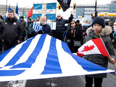 Parade participants march along Jean-Talon St. during the Greek Independence Day celebrations in Montreal on Sunday, March 26, 2023.