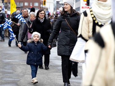 Three-year-old Elpida is accompanied by her godmother, Artemis, as they march in the Greek parade during the Greek Independence Day celebrations in Montreal on Sunday, March 26, 2023.