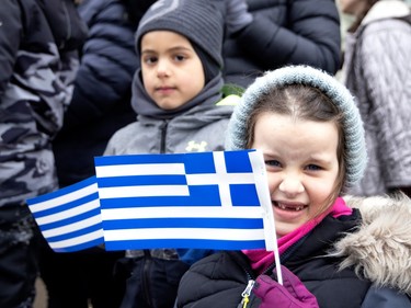 Six-year-old Penelope McDomell watches the Greek parade on Jean-Talon St. during the Greek Independence Day celebrations in Montreal on Sunday, March 26, 2023.
