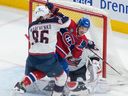 Blue Jackets' Kirill Marchenko (86) tries to remove Canadiens' Rafaël Harvey-Pinard (49) from in front of Columbus goaltender Elvis Merzlikins (90) in Montreal on Saturday, March 25, 2023.
