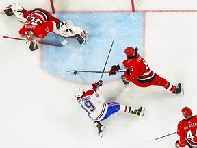 Hurricanes defenceman Jalen Chatfield (5) clears the puck away from Canadiens left-wing Rafaël Harvey-Pinard (49) Feb. 16, 2023.