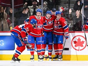 Canadiens' Sean Farrell, second from right, celebrates his first NHL goal with teammates, from left, Joel Edmundson, Jake Evans and Brendan Gallagher Thursday night at the Bell Centre.