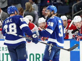 Tampa Bay Lightning players Brandon Hagel (38) and Ian Cole (28) celebrate after Hagel's goal Saturday in Tampa, with Canadiens' Jonathan Drouin (centre) watching from the bench.