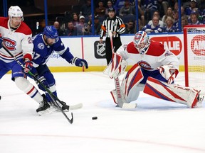 Tampa Bay Lightning's Alex Killorn (17) skates with the puck as Canadiens' Denis Gurianov (25) and goaltender Sam Montembeault defend during the first period at Amalie Arena in Tampa on Saturday, March 18, 2023.