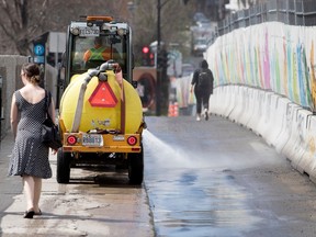 Pedestrians in spring dress share the sidewalk with a City of Montreal street cleaner as they do spring cleaning along Avenue de L' Hotel-de-Ville Street in Montreal on April 27, 2017.