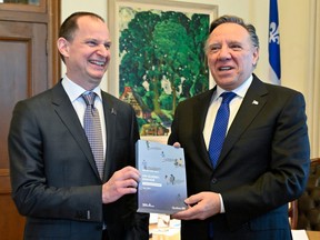 Quebec Finance Minister Eric Girard, left, and Quebec Premier François Legault hold a copy of the budget speech, Tuesday, March 21, 2023 at the premier's office in Quebec City.