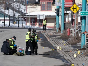 Police officers investigate the scene of a fatal incident on March 14, 2023 in Amqui Que. Two people were killed and nine others were injured.
