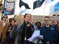 Julie Bouchard stands in front of union members holding flags