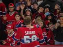 Montreal Canadiens defenceman David Savard and one of his children wave to fans at the Montreal Canadiens skills competition at the Bell Centre in February.
