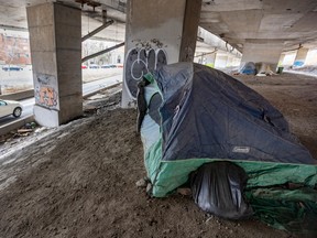 A tent belonging to unhoused people living under the Ville-Marie Expressway overlooks the westbound Atwater exit in Montreal on Monday April 3, 2023.