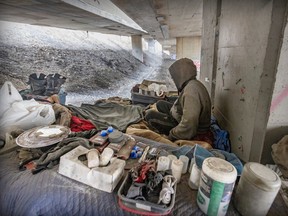An unhoused man sits in his encampment under the Ville-Marie Expressway in Montreal on Monday April 3, 2023. The man has lived there for two years.