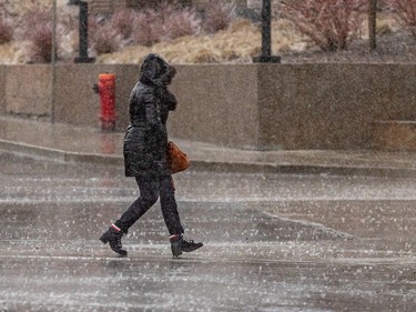 A pedestrian crosses the street during freezing rain in Montreal on Wednesday April 5, 2023.