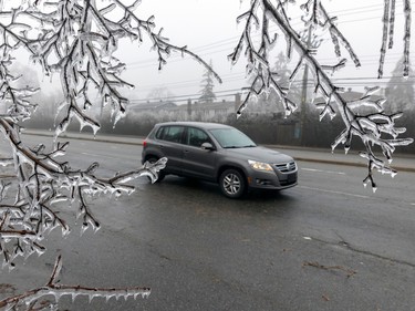 Traffic detours around branches that fell on St-Charles Boulevard in Beaconsfield on Thursday April 6, 2023 after an ice storm hit the city the day before.