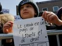 A boy holds message at a demonstration at Place Émilie-Gamelin in Montreal Sunday, April 7, 2019 at a demonstration to denounce the Quebec government's secularism bill.