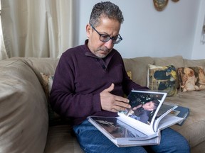 Mustapha Ouahdi looks through a photo album of pictures of his son Hani at his home in Laval.