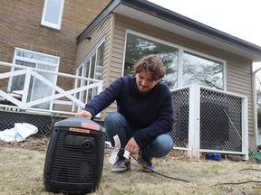 Michael Johnson makes sure  his generator is running smoothly as he gets ready for another night without power at his Pointe-Claire home on Tuesday evening.