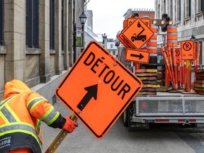 City worker Patrick Latulip picks up stray orange cones and signs on St-Vincent St. in Old Montreal April 12, 2023.