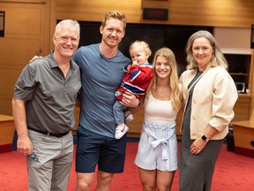 Canadiens defenceman Mike Matheson holds son Hudson in his arms while posing for photo with his parents, Rod and Margaret, and his wife, Emily, in Canadiens' Bell Centre locker room in 2022.