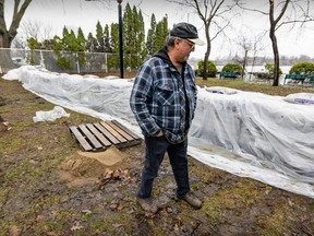 Jean-Yves St. resident William Groulx looks at a dike built to hold back the rising Rivière des Prairies in the L'Île-Bizard—Sainte-Geneviève borough on Monday.