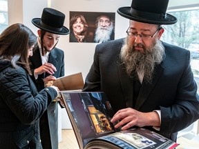 Mayer Feig, a member of the Quebec Council of Hasidic Jews, looks at one of Agnieska Traczewska’s books at opening of the exhibition A World Rekindled on Tuesday April 18, 2023.