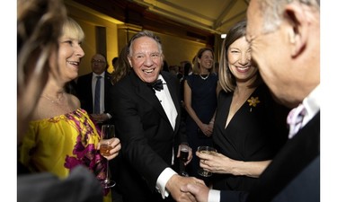 Quebec Premier François Legault is greeted by Health Minister Christian Dubé and Andrea Seale, centre, CEO of the Canadian Cancer Society at the Daffodil Ball in Montreal April 20, 2023.