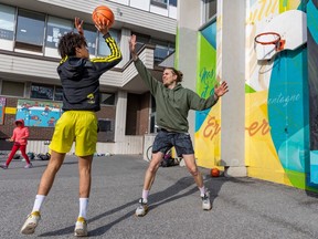 Louis-Pierre Poulin, right, plays one-on-one with family friend Luka Sanon-Radulescu at the basketball hoop behind École primaire au Pied-de-la Montagne-Pavillon Jean-Jacques Olier on Pine Ave. In March, Poulin launched an online petition calling on city officials to install basketball courts at Jeanne-Mance and La Fontaine parks.