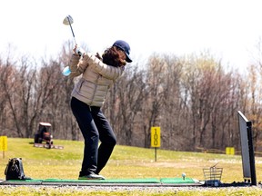 Ling Luo goes through a bucket of balls on the driving range at Golf Dorval in April 2022.