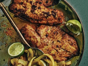 The fried tilapia in My Thali: A Simple Indian Kitchen is served with hot onions and lime wedges.