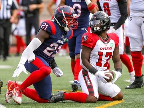 Alouettes' Chris Ackie celebrates after tackling Redblacks' DeVonte Dedmon during a game at Molson Stadium in 2021.