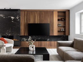 A large, dark brown walnut wall unit with open shelving for art on the right and a gas fireplace encased in black marble, on the left.