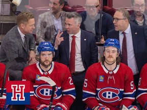 Montreal Canadiens head coach Martin St. Louis speaks with assistants Trevor Letowski, left, and Stephan Robidas during third period of his team's game against the Boston Bruins on April 13, 2023.