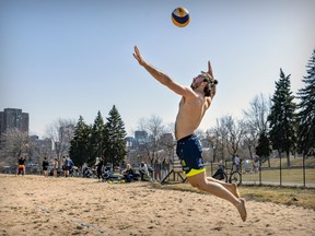 Vivien Tournier leaps into the air to serve during beach volleyball game in Jeanne-Mance Park April 10, 2023.