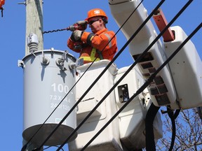 Don McPhee from Holland Power in Ontario drills new holes in pole to secure a transformer on des Ecores St. in Rosemont on Monday April 10, 2023.