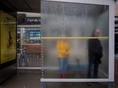 People wait for a bus in Monkland Village after freezing rain hit Montreal on April 5, 2023.