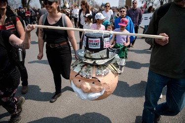 Protesters march with an effigy of Monopoly mascot, Rich Uncle Pennybags, during the Earth Day Protest on April 22, 2023, in Montreal.