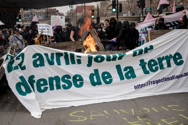 A protester adds fuel to barricade put up by Black Bloc at the end of the Earth Day Protest on April 22, 2023, in Montreal.