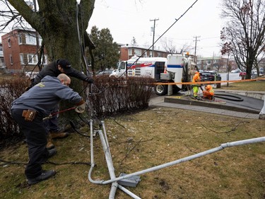 A Hydro-Québec crew fixes lines where they broke off from a home on April 6, 2023, a day after freezing rain and strong winds cut power hundreds of thousands of people the day before.