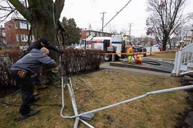 A crew from a local electric company fix lines where they broke off from a Montreal home a day after freezing rain and strong winds cut power to than a million people in Quebec.