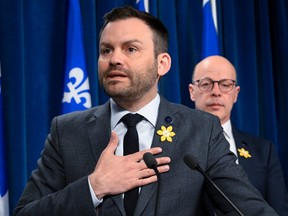 Parti Québécois Leader Paul St-Pierre Plamondon reacts to reporters' questions over the revelation that former PQ MNA Catherine Fournier was the victim in the Harold LeBel sexual-assault case. PQ MNA Joel Arseneau, right, looks on.