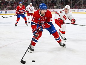 Canadiens centre Nick Suzuki (14) plays the puck against Carolina Hurricanes defenceman Brady Skjei (76) during the third period at the Bell Centre in Montreal on Saturday, April 2, 2023.