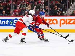 Canadiens' Joel Armia keeps the puck away from Hurricanes' Jalen Chatfield during third-period action at Bell Centre Saturday night. Armia returned to the lineup after missing 19 games.