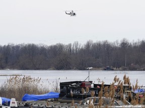 A police helicopter searches the area in Akwesasne, Que., Friday, March 31, 2023. Federal prosecutors in the United States say an Indian man living in Canada was paid thousands of dollars to smuggle other Indian nationals into the U.S. through Akwesasne Mohawk reserve.