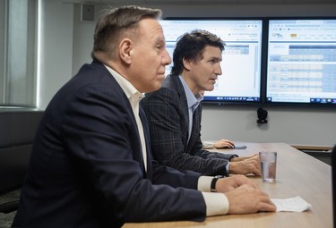 Prime Minister Justin Trudeau, right, and Quebec Premier François Legault attend a briefing at a Hydro-Québec operations centre following Wednesday's ice storm in Montreal, Thursday, April 6, 2023.