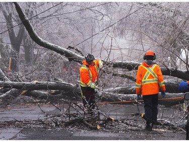 Montreal city workers clear fallen branches Thursday, April 6, 2023 after Wednesday's ice storm left more than a million customers without power in Quebec.