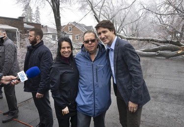 Prime Minister Justin Trudeau and Mayor Valérie Plante pose for a photo with a local resident Thursday, April 6, 2023, after Wednesday's ice storm left more than a million customers without power in Quebec.