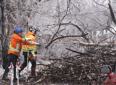 Montreal city workers clears fallen branches after Wednesday's ice storm, which left more than a million customers without power in Quebec.
