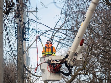 A Hydro worker surveys a power line following an ice storm in Montreal April 7, 2023. Hydro-Quebec says it's restored power to more than half a million customers since Wednesday's ice storm, but more than 600,000 remain in the dark.