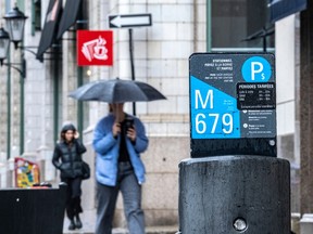 A sticker affixed to a parking meter post in Old Montreal notes the price and times for parking have increased. The city says it will pause this change, though the stickers that have already been placed will stay for now.