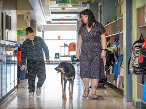 Grade 4 student Patrik Kismarczi joins principal Brigitte Valois as she walks her dog Sully through the hall at Birchwood Elementary School in St-Lazare on Tuesday, May 9, 2023.